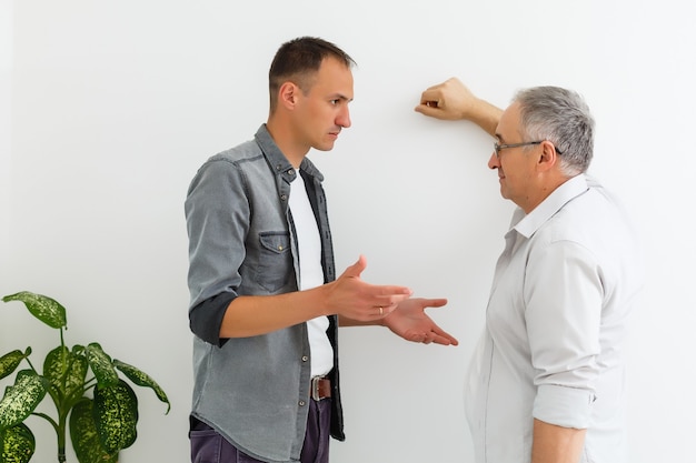 Senior Father With Adult Son on a white wall