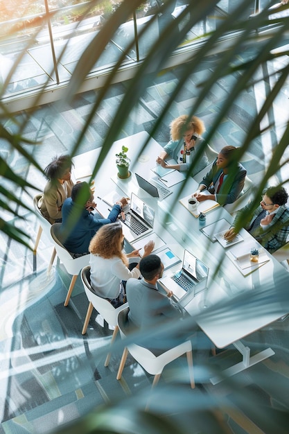 Senior female ceo and multicultural business people discussing company presentation at boardroom table Diverse corporate team working together in modern meeting room office Top view through glass