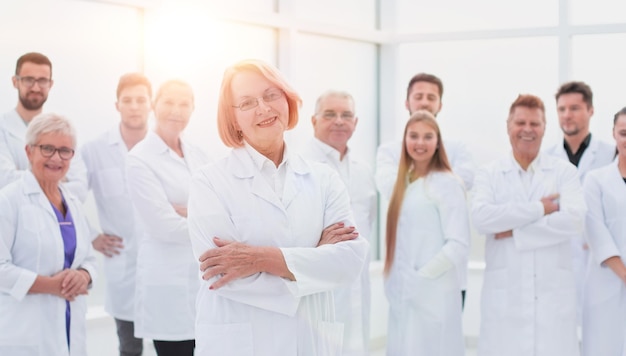 Senior female doctor standing in front of her colleagues