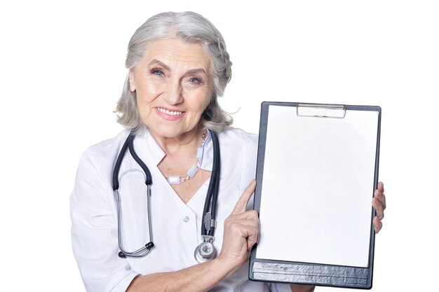 Senior female doctor with clipboard posing against white background