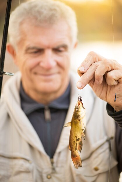 フックに魚を持っている上級漁師。