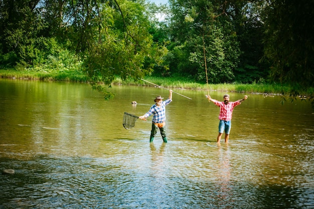 Senior fisherman in suit and bearded casual man fishing with fishing rod