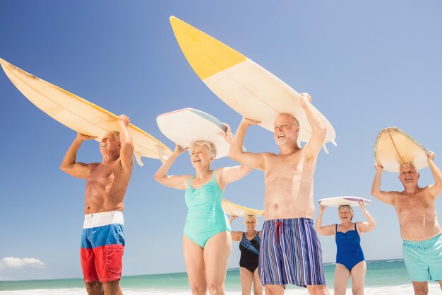 Senior friends holding surfboard