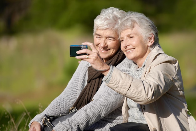 Фото Старшие друзья на открытом воздухе и селфи для фотографии картинки и счастливые для воспоминаний в природе и пожилых женщин связываются и общаются с улыбкой смешно и смеются вместе на пенсии