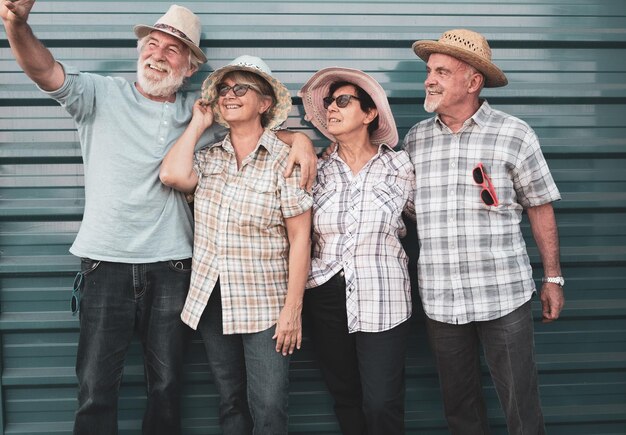 Senior friends taking selfie while standing against shutter