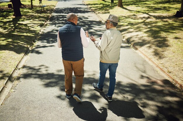 Photo senior friends walking and talking in park nature and outdoor in retirement with support and communication elderly men and behind people on path in new york with conversation and community