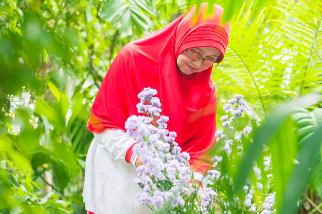 Senior gardener looking at beautiful flowers