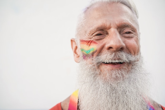 Senior gay man smiling during lgbt pride protest - Focus on face