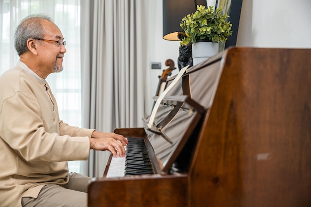 Senior gepensioneerde man met bril leert thuis piano spelen