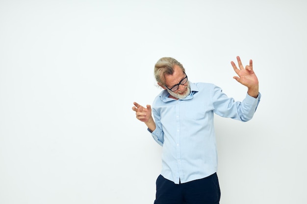 Senior greyhaired man in blue shirts gestures with his hands isolated background