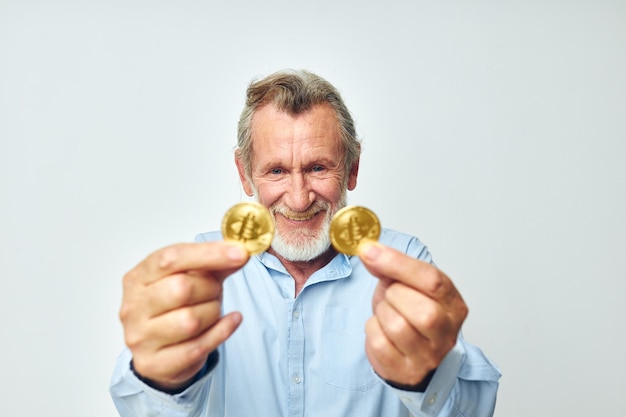 Senior greyhaired man cryptocurrency bitcoin face close up investment light background