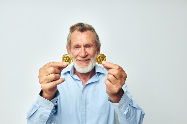 Senior greyhaired man cryptocurrency bitcoin face close up investment light background