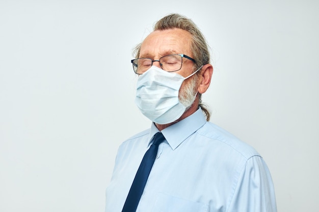 Senior greyhaired man medical safety mask health isolated background