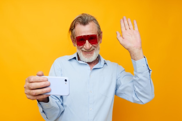 Senior grijsharige man blauwe shirts met bril neemt een selfie bijgesneden weergave