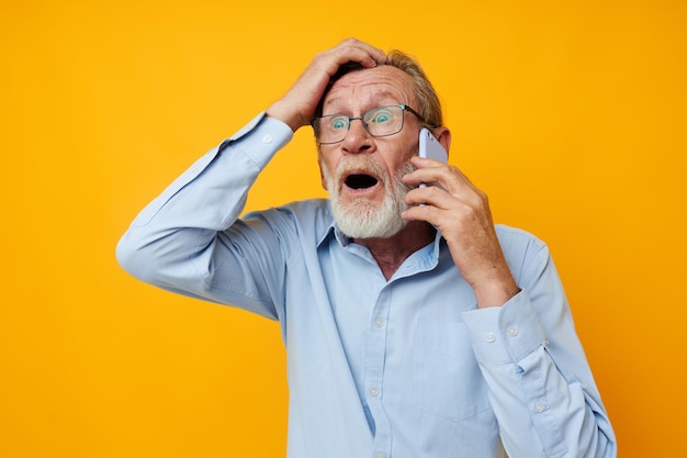 Senior grijsharige man grijze baard met bril praten aan de telefoon geïsoleerde achtergrond