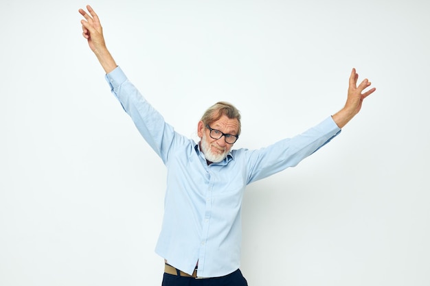 Senior grijsharige man in blauwe shirts gebaren met zijn handen geïsoleerde achtergrond