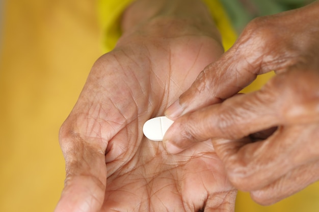 Senior hand holding pills with copy space