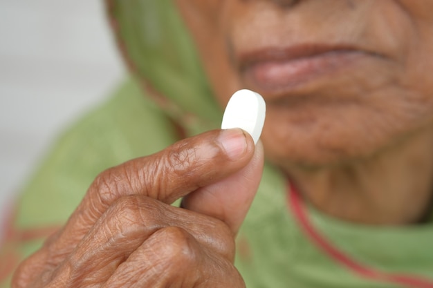 Senior hand holding pills with copy space