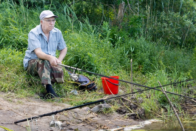 Старший человек с ограниченными возможностями, ловящий рыбу на озере