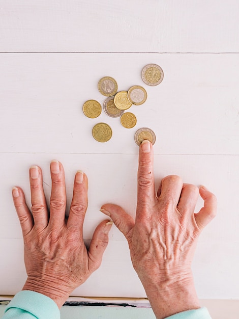 senior hands counting euro coins on the table