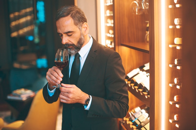 赤ワインを飲むシニアハンサムな男