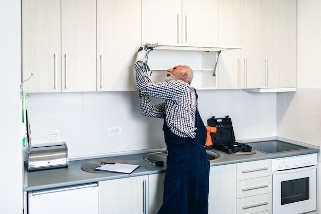 Senior handyman working in the kitchen. renovation.