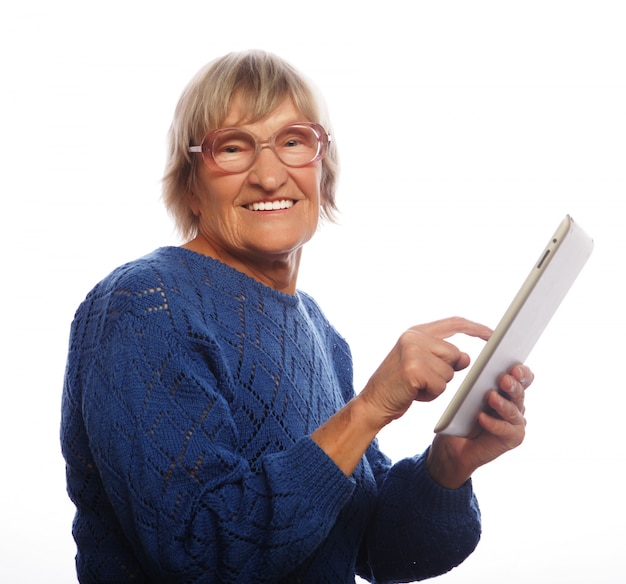 Старшая счастливая женщина используя ipad