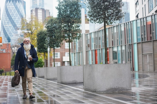 Senior hipster zakenman lopen om te werken aan de stad