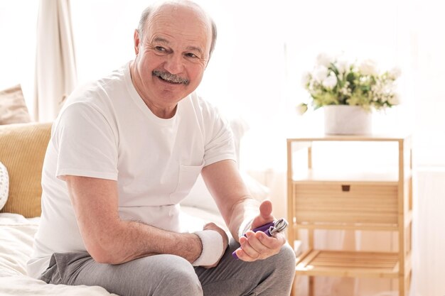 Senior hispanic man training his arm with hand expander