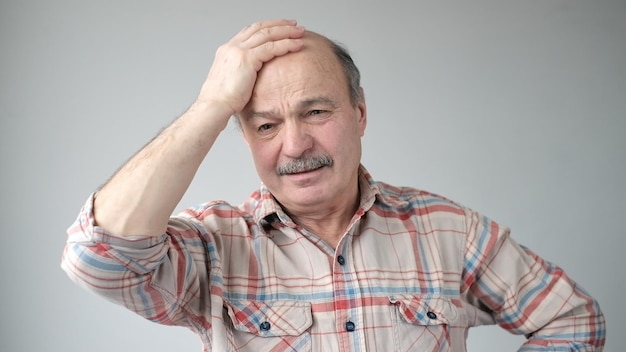 Senior hispanic man trying to remember something or having terrible headache