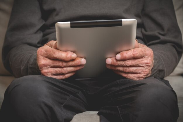 Senior holding a tablet in hands