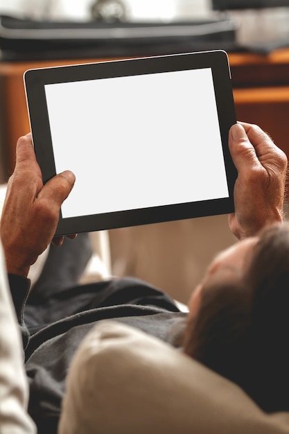 senior holding a tablet in hands