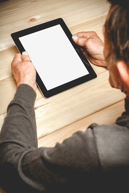 Senior holding a tablet in hands