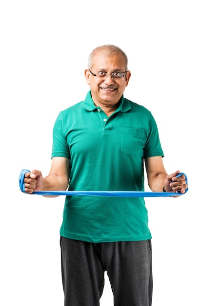 Senior indian asian healthy sportsman playing individual sport or gymming , isolated on plain background