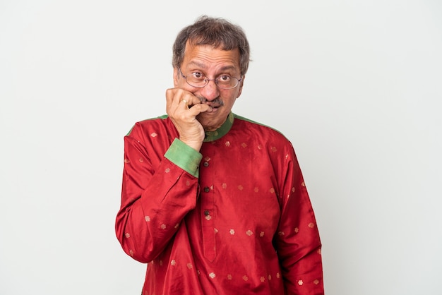 Senior indian man wearing a Indian costume isolated on white background biting fingernails, nervous and very anxious.