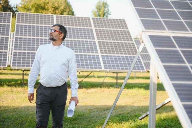 Senior ingenieur werkt aan een zonnepanelenboerderij Het concept van groene energie