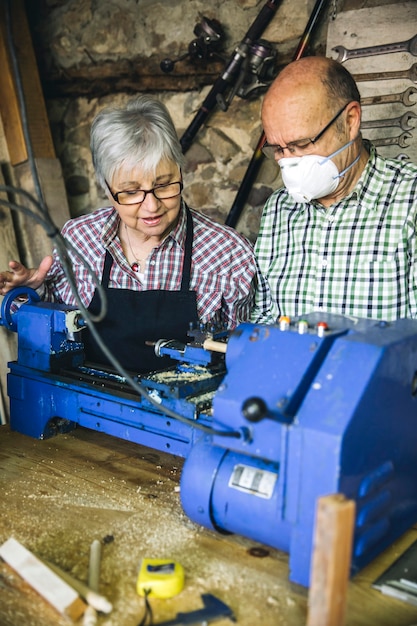 Foto senior koppel aan het werk in een timmerwerkplaats