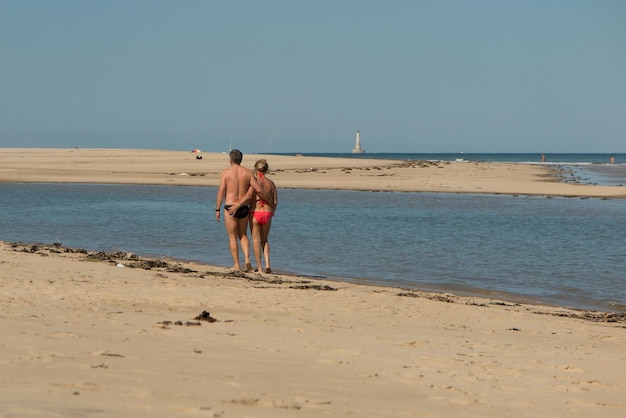 Senior koppel wandelen langs het zomerstrand