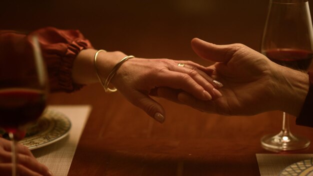 Senior love couple hands touching each other in restaurant closeup rich grandparents enjoying retirement life together unknown tender old husband wife romantic dinner home care family relationship