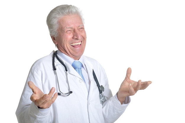 Senior male doctor posing against white background