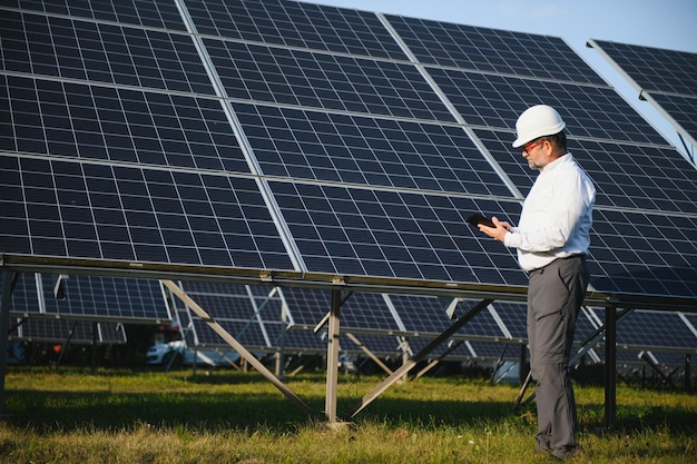 Senior male engineer inspects solar panels on farm Clean energy