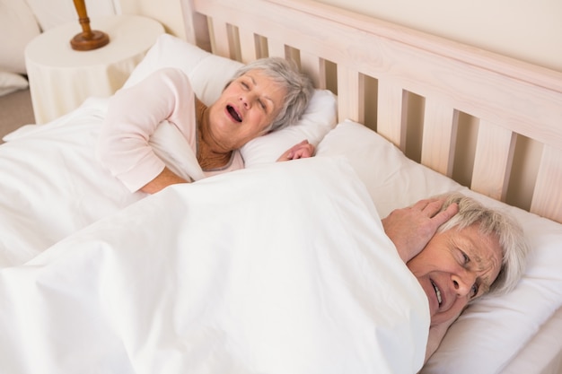 Photo senior man blocking out his wifes snoring