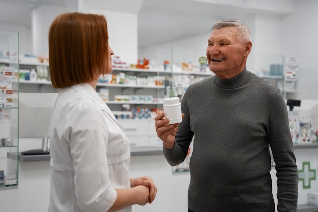 Фото Старший мужчина покупает лекарства в аптеке