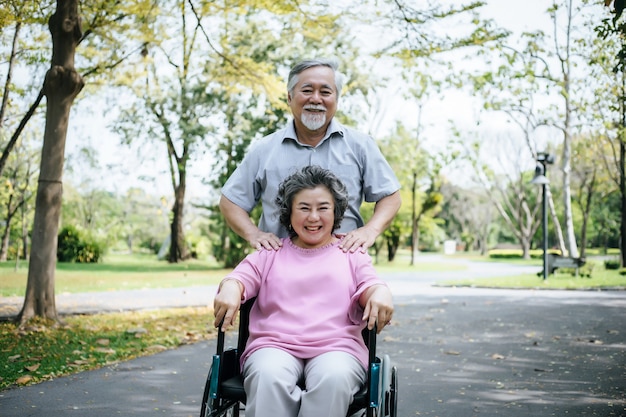 Senior man caring for  disabled wife in his wheelchair.