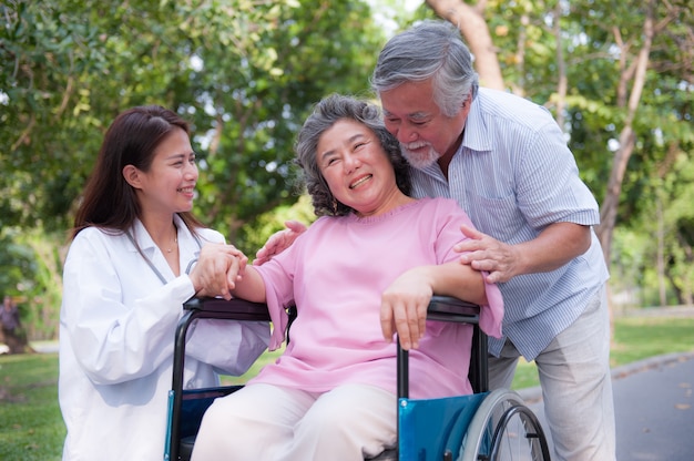 Photo senior man caring for disabled wife in his wheelchair.