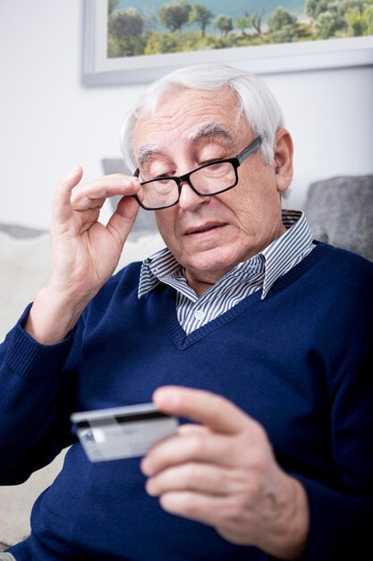 Старший мужчина проверяет свою кредитную карту