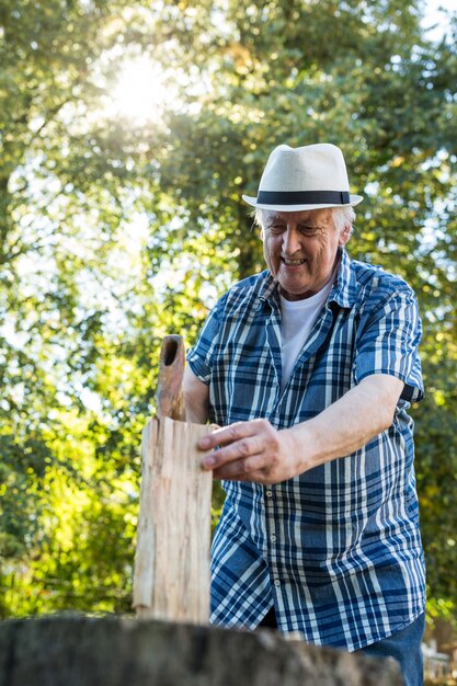 Senior man chopping firewood