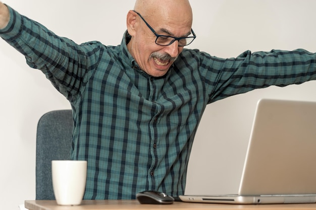 Uomo anziano dietro un computer in un ufficio a casa