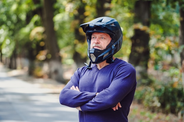 屋外の暗いヘルメットの年配の男性