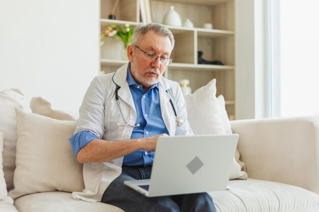 Photo senior man doctor with laptop talk on video call have consultation with patient professional senior